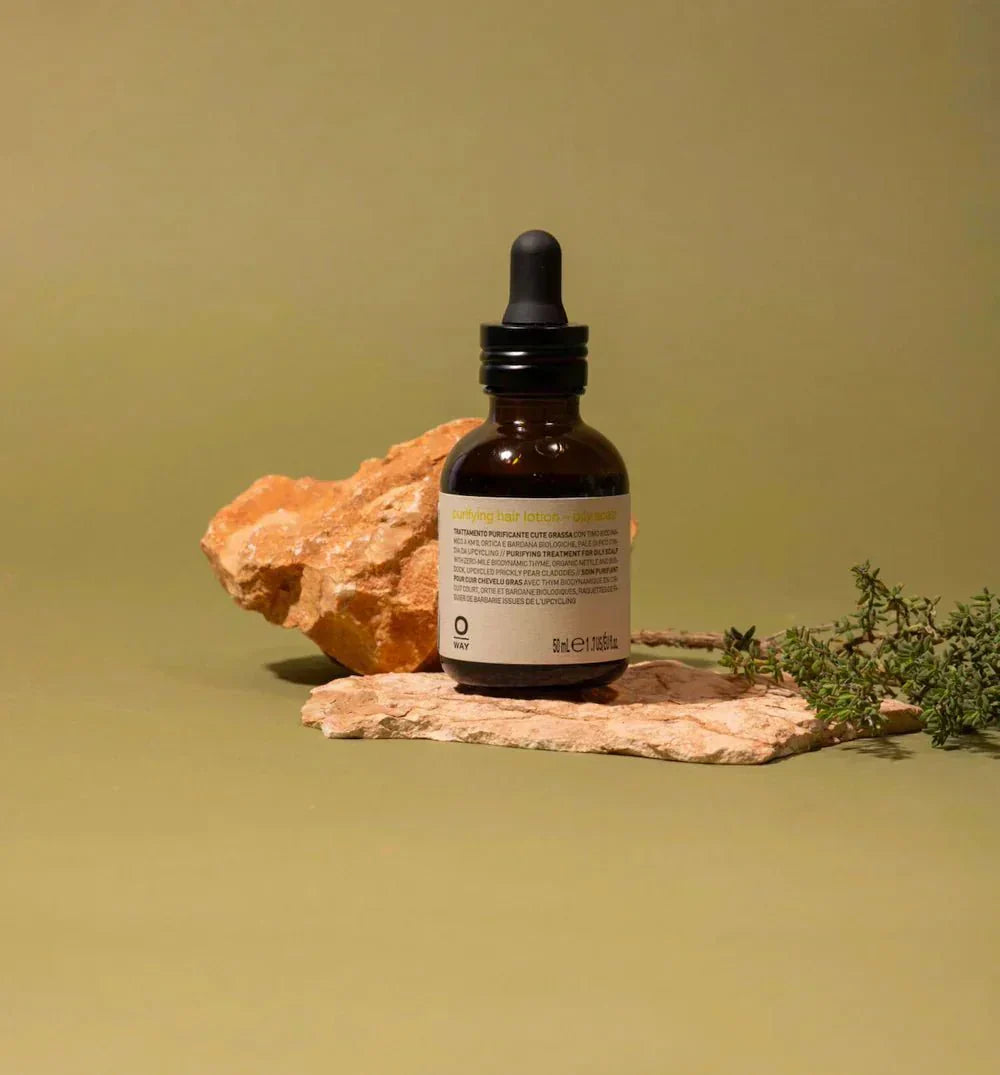 A glass bottle on a clay rock with a tan background