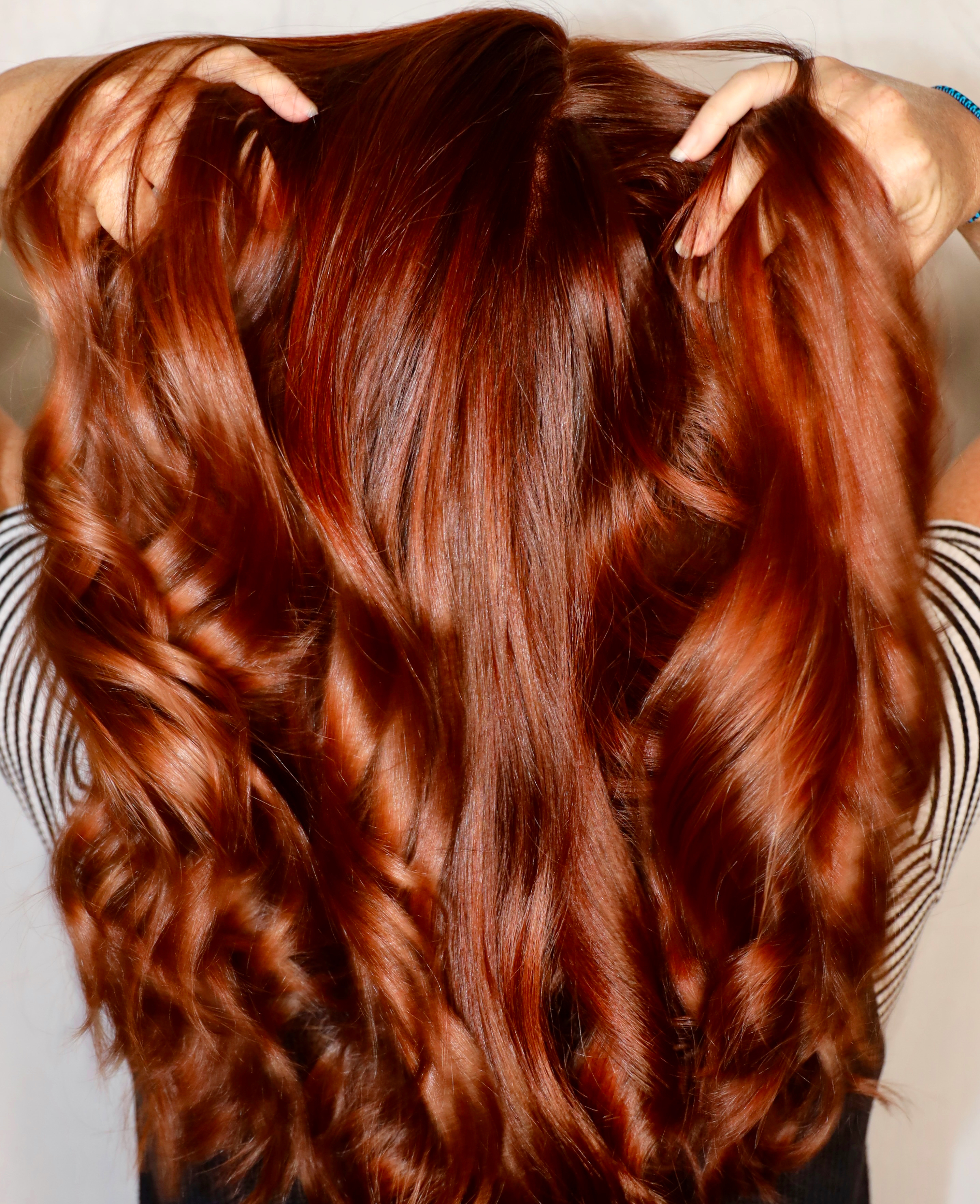 Close-up of a person with long, wavy red hair.