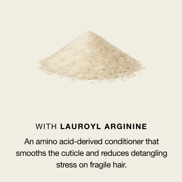 A small pile of fine off-white granules centered on a light warm beige background, with text below reading “WITH LAUROYL ARGININE” and a descriptive sentence about smoothing cuticle and reducing detangling stress on fragile hair.