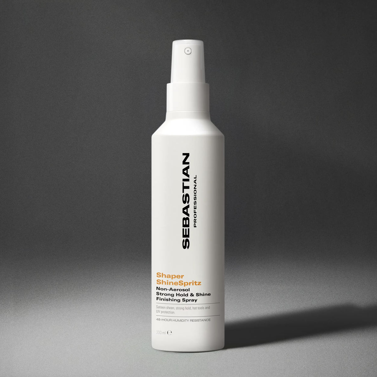 A white bottle of Sebastian Professional ShineSpritz styling spray with black and orange text, set against a dark gray gradient background.