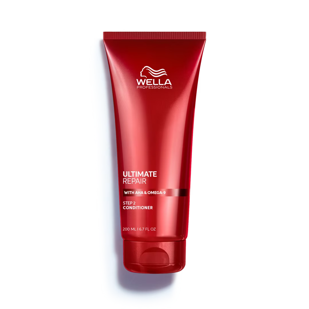 Red Wella Professionals conditioner bottle on a white background