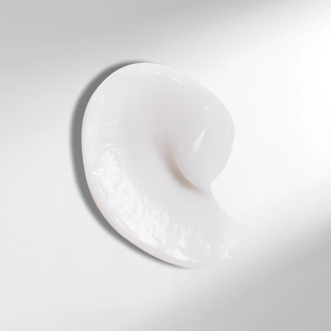 White cream or gel in a heart-shaped swirl on a light gray background
