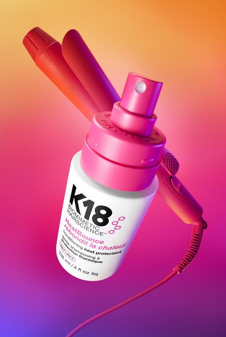 K18 hair product with a pink nozzle on a gradient background