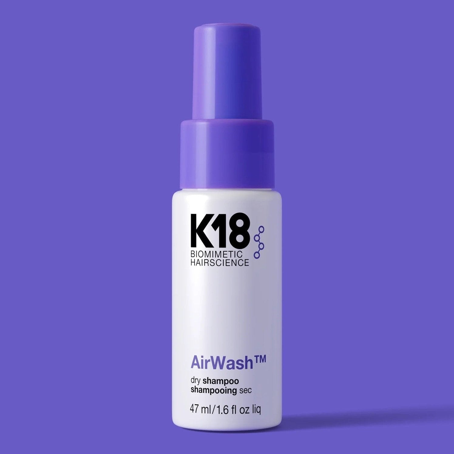 K18 AirWash dry shampoo bottle on a purple background