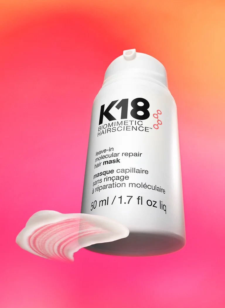 K18 hair mask bottle with a pink and orange gradient background