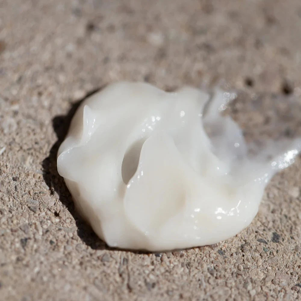A small dollop of Oway Moisturizing Hair Mask, a deep hydration mask for dry or dehydrated hair, sits on a rough, textured beige surface.