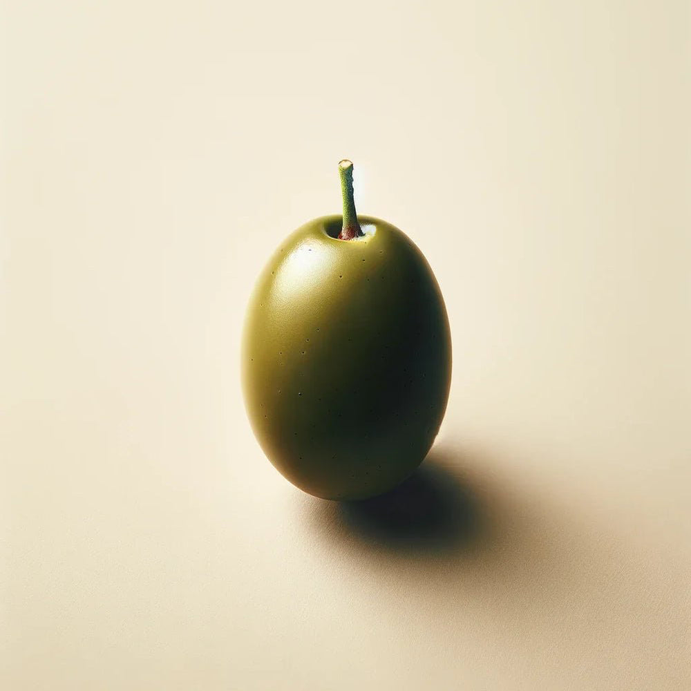A single green olive with a stem rests on a smooth surface, much like Oway Moisturizing Hair Bath—a hydrating shampoo for dry, lackluster hair—poised to nourish and bring shine.