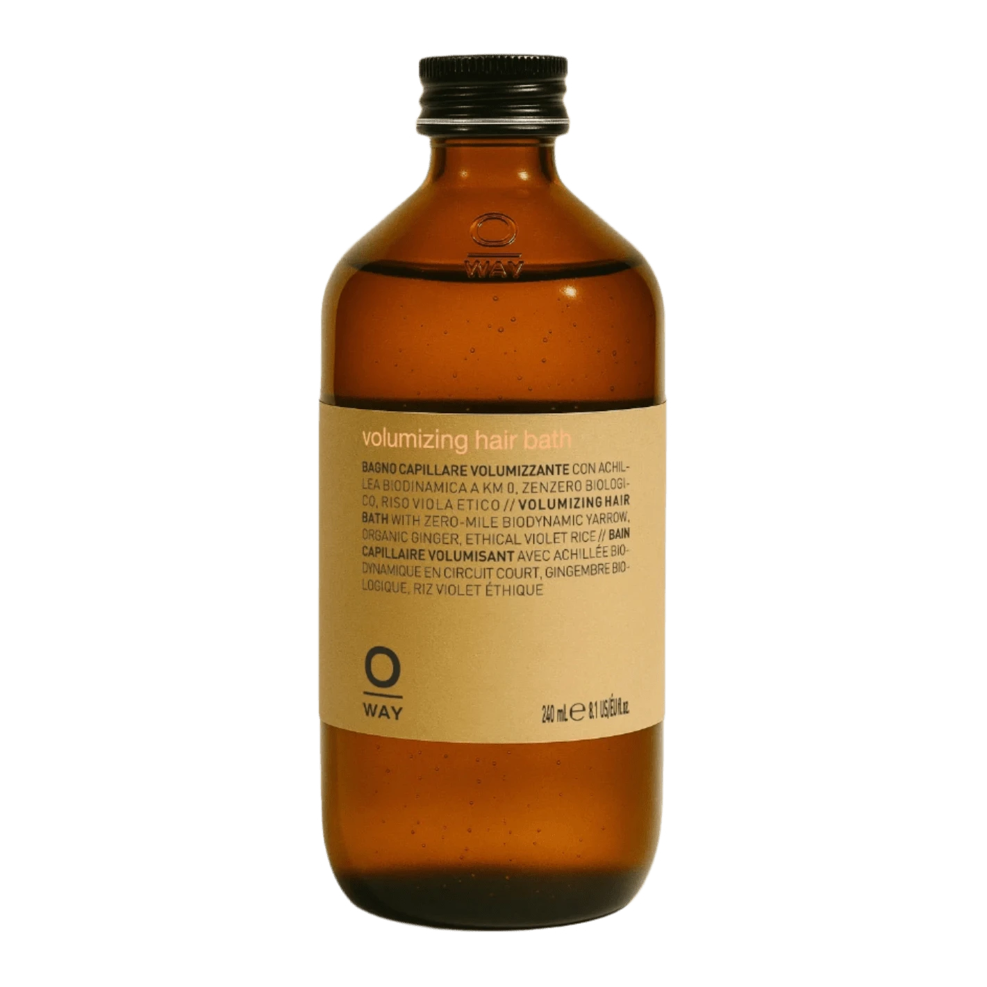 A brown glass bottle with a black cap and a beige "Oway Volumizing Hair Bath" label for fine or limp hair, featuring multilingual product info, sits against a green textured background. Brand: Oway.