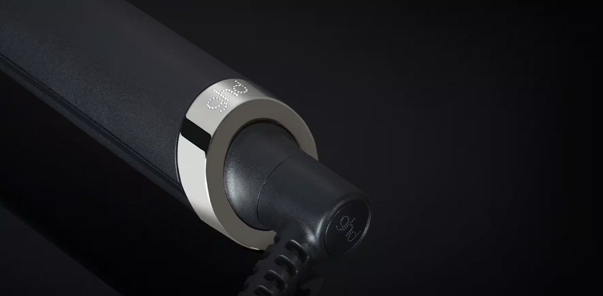 Black and silver cylindrical device with a brand logo on a black background