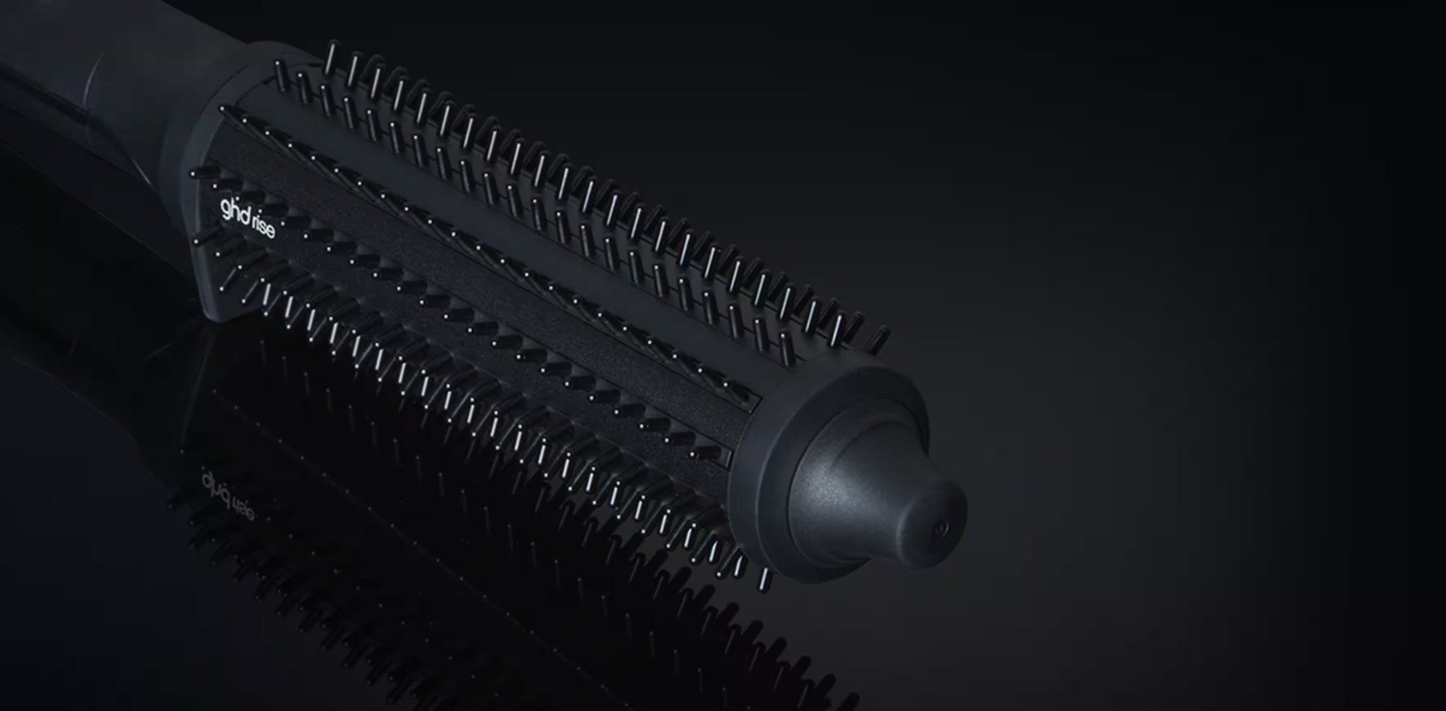 Black hairbrush with bristle head on a black background