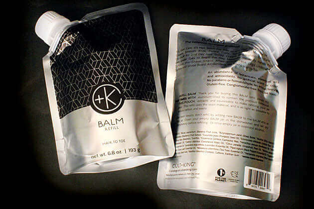 Two silver and black refill pouches of Cult and King BALM | Hair to Toe are shown: one displays the Cult and King logo and volume, while the other shows back details with product info plus moisturizing skin and hair care instructions.