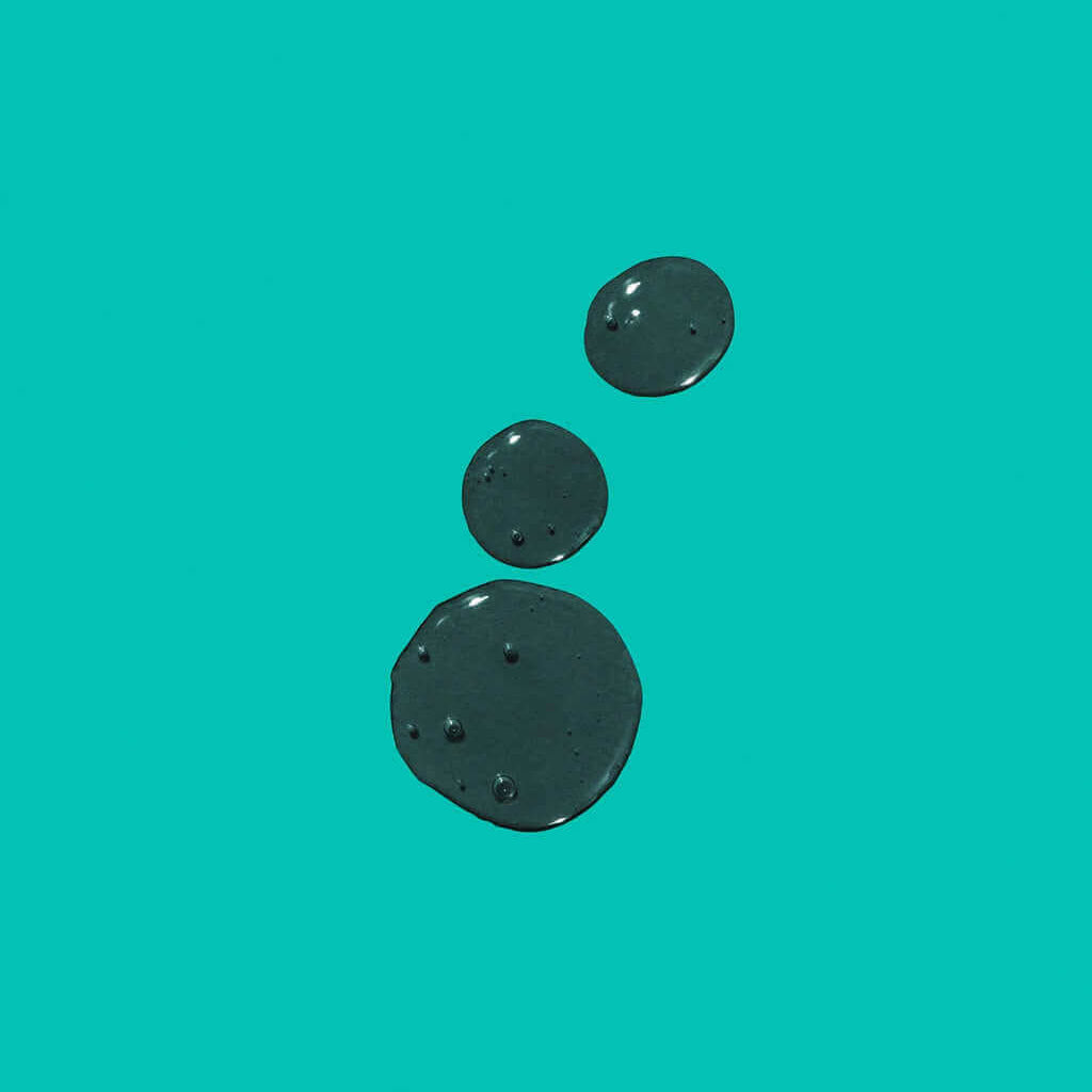 Three dark droplets of K18 PEPTIDE PREP Detox Shampoo by K18 Hair Repair are lined up vertically on a teal background, highlighting an innovative approach to hair and scalp cleansing.