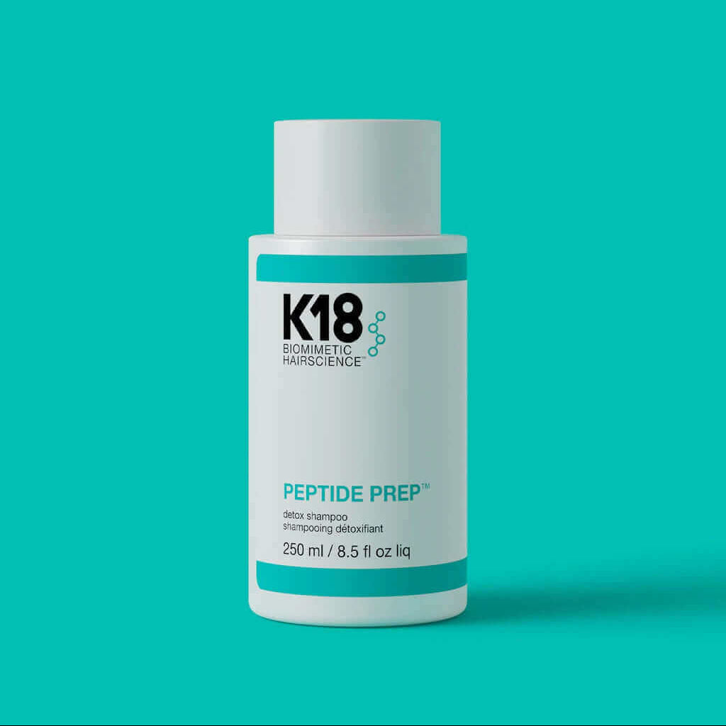A 250 ml bottle of K18 PEPTIDE PREP Detox Shampoo by K18 Hair Repair, formulated with K18PEPTIDE™ for advanced scalp cleansing, shown on a solid turquoise background.