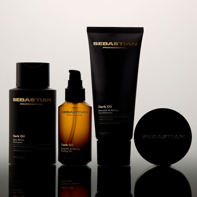 Sebastian hair care products including shampoo, conditioner, and oil on a reflective surface with a light gray background.