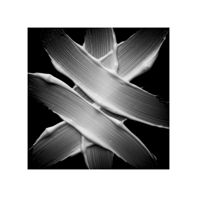 A black-and-white abstract photograph of thick, textured Potion 9 Shampoo strokes arranged in a cross-like pattern against a solid black background.