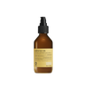 A brown Oway Sublime Hair Milk bottle is centered on a black textured background, emphasizing its lightweight leave-in formula that boosts softness and shine.