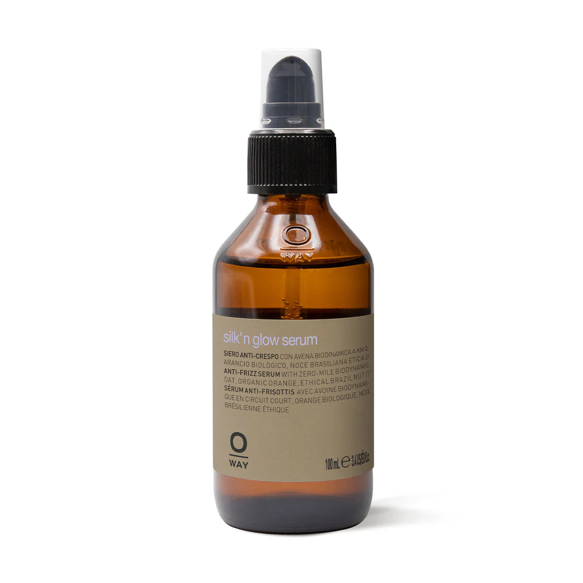 A 100 ml brown glass bottle with a black pump labeled "Oway Silk’N Glow Serum | Anti-Frizz Shine Serum for Dry, Frizzy Hair," enriched with biodynamic oat and Brazil nut oil.