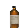 A brown Oway Smoothing Conditioner bottle, designed for frizzy hair with biodynamic caraway, features a silver cap and minimalistic look, set against a black textured background.