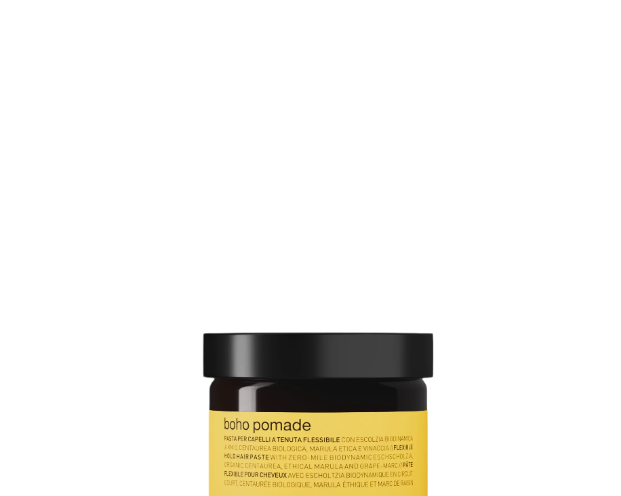 A small amber jar with a black lid labeled “Oway Boho Pomade” rests on a dark textured surface, offering a laid-back, matte finish with flexible hold.