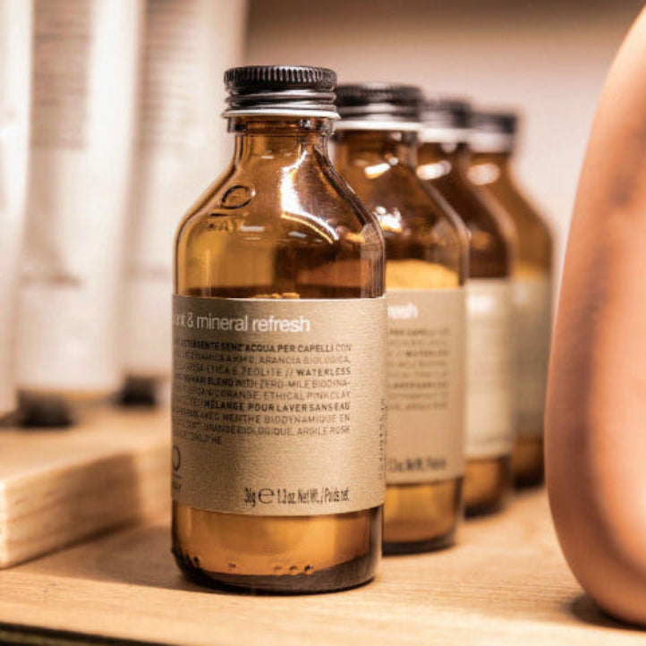 Row of small bottles with labels on a wooden surface