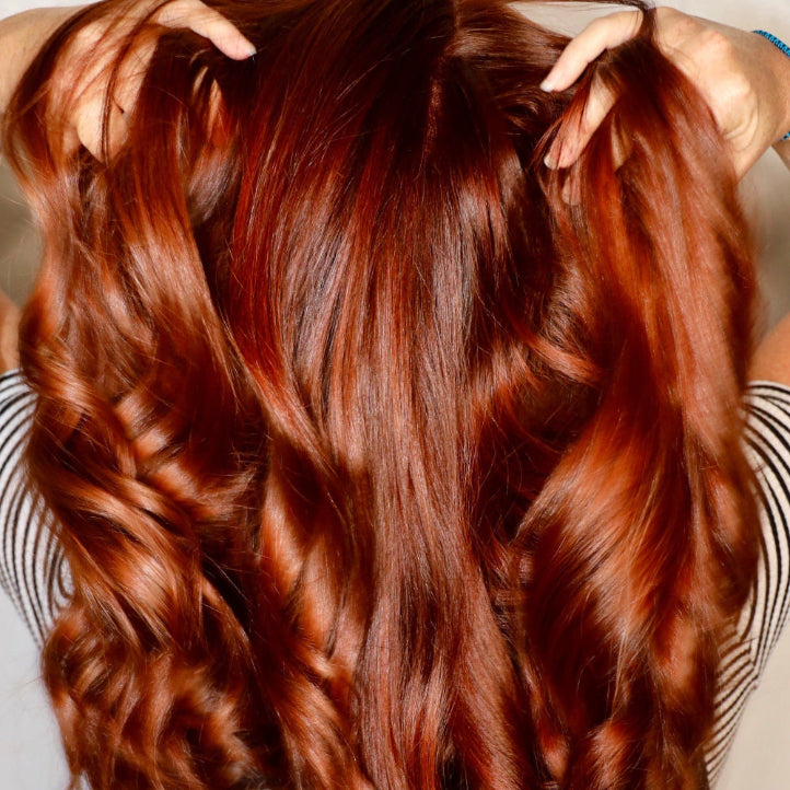 Close-up of a person with long, wavy red hair.