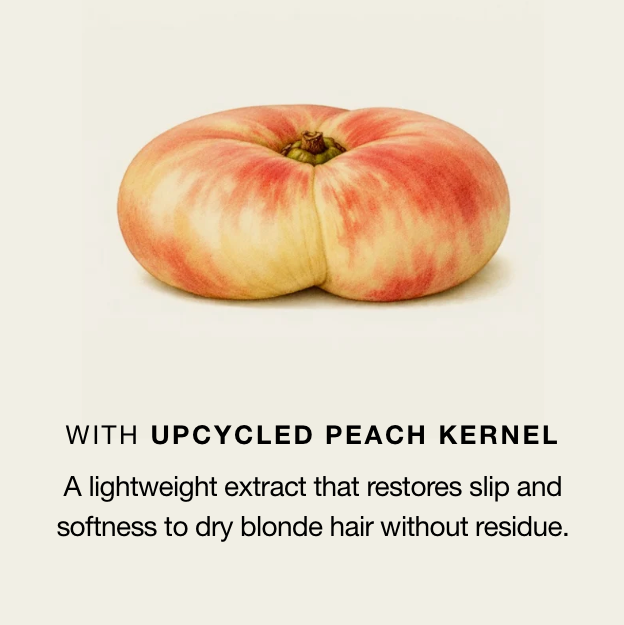 A peach-shaped cosmetic product centered on a light cream background, with text below reading 'WITH UPCYCLED PEACH KERNEL' and a descriptive claim about restoring slip and softness to dry blonde hair.