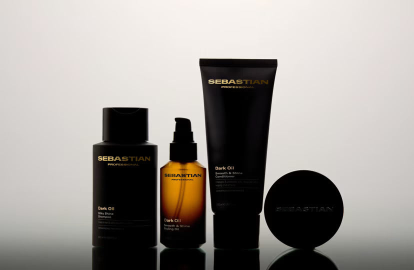 Sebastian hair care products on a reflective surface with a gradient background
