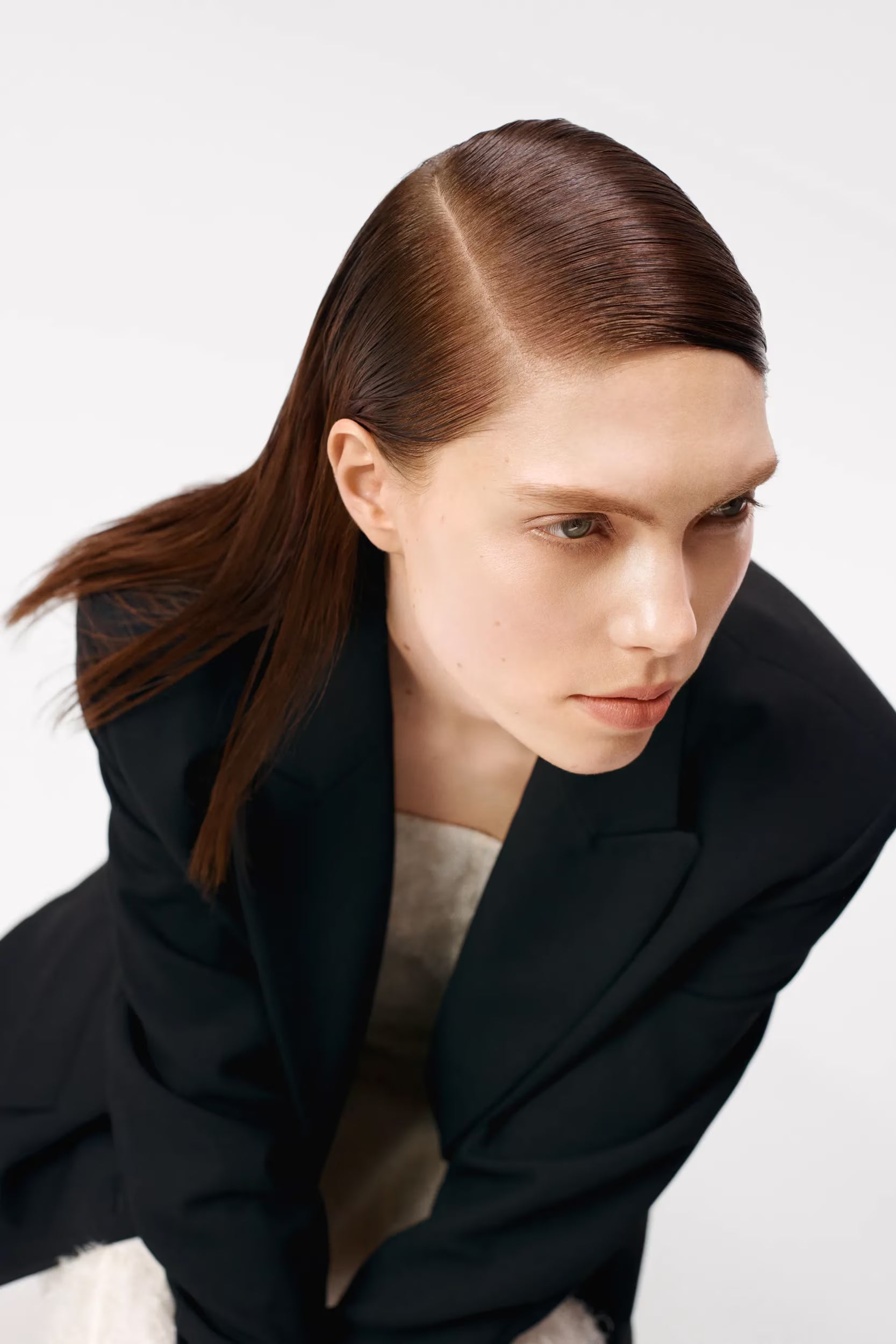 Woman wearing a black coat against a white background