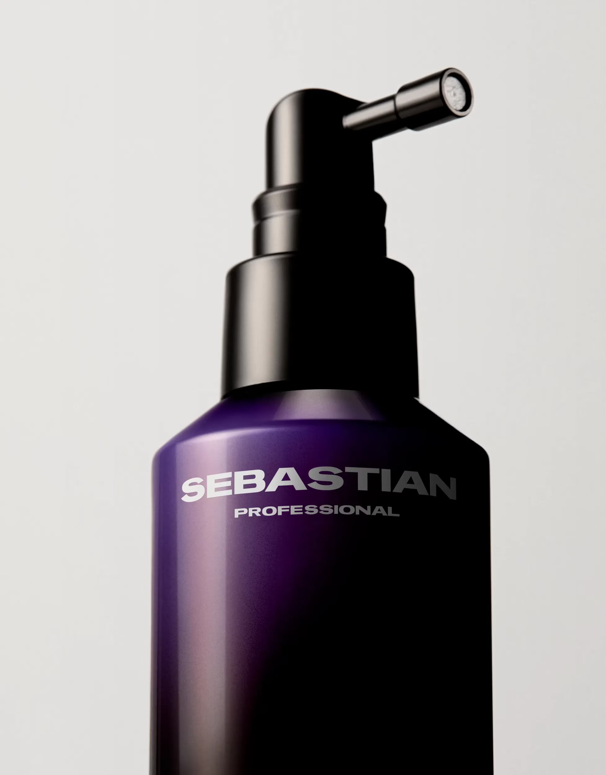 Purple bottle with black pump labeled 'Sebastian Professional' on a light gray background