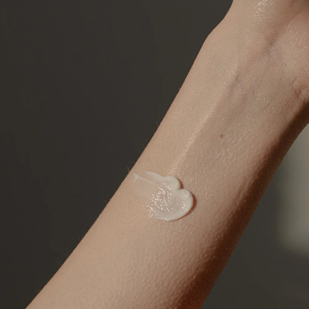 A close-up of a forearm with Oway After Sun Body Balm by Oway, soothing and hydrating sun-exposed skin gently applied.