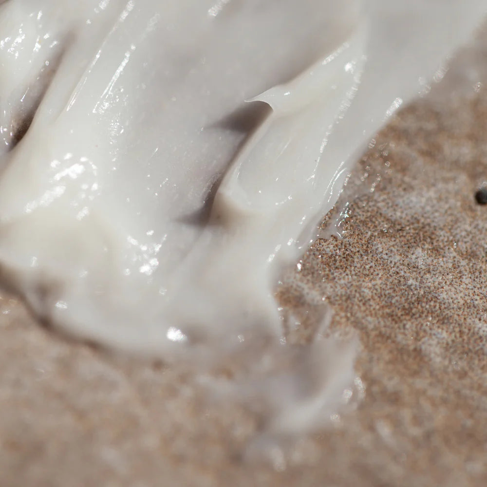 Close-up of Oway Curly Hair Mask | Definition and Moisture Mask for Natural Curls spread on a textured brown surface, ideal for nourishing and defining natural curls.