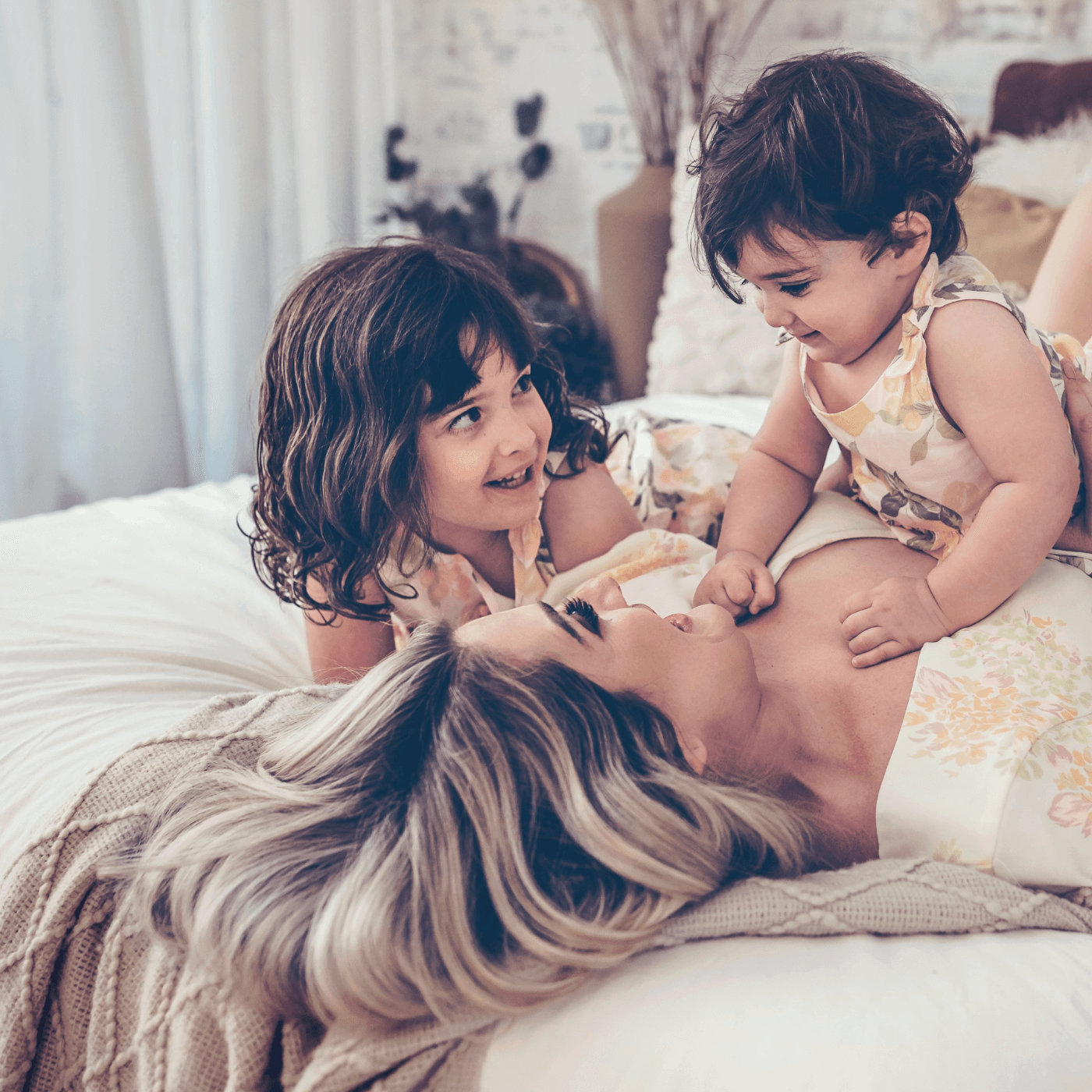Blonde Balayage hair models and her children on a bed