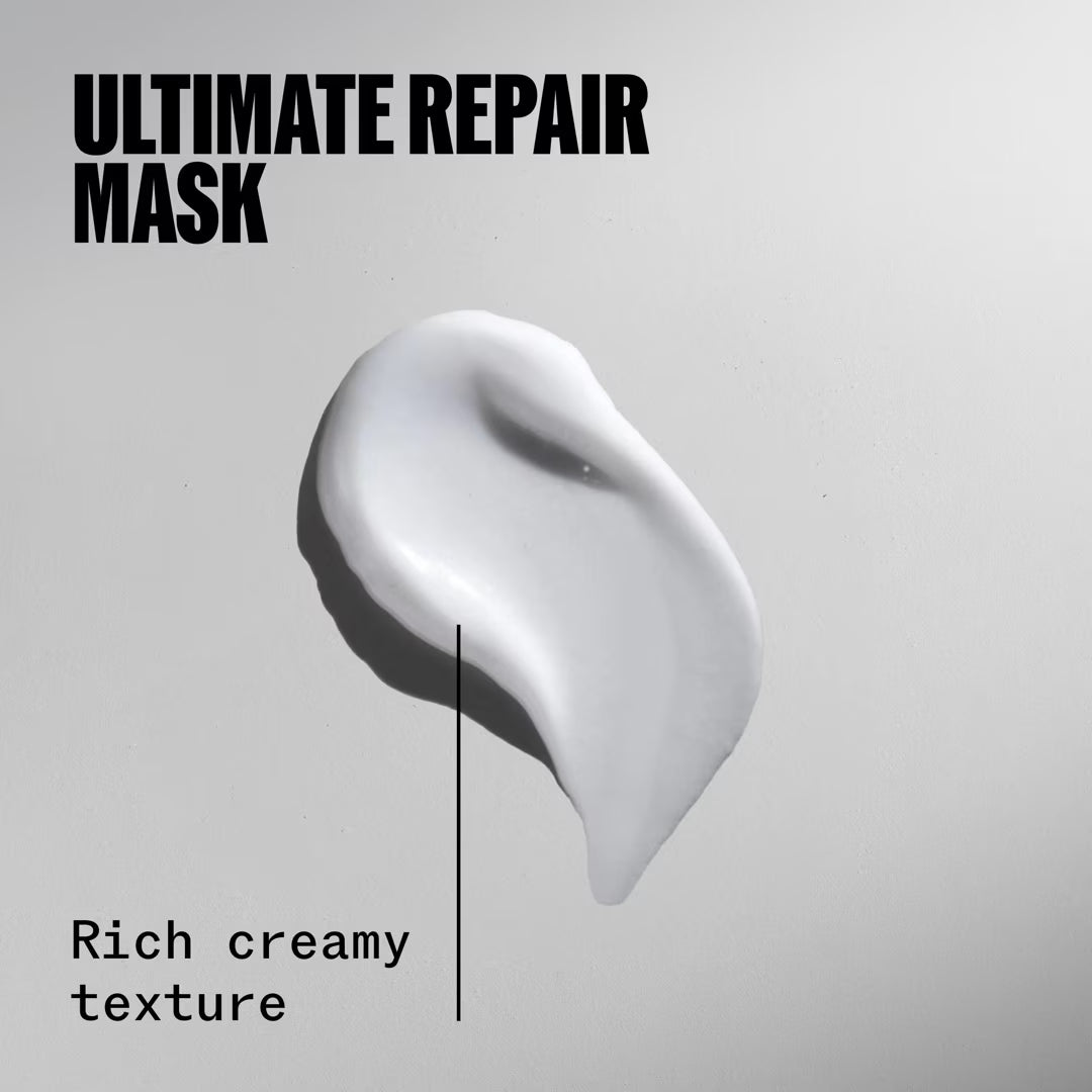 White cream of an ultimate repair mask on a gray background with text describing its texture.