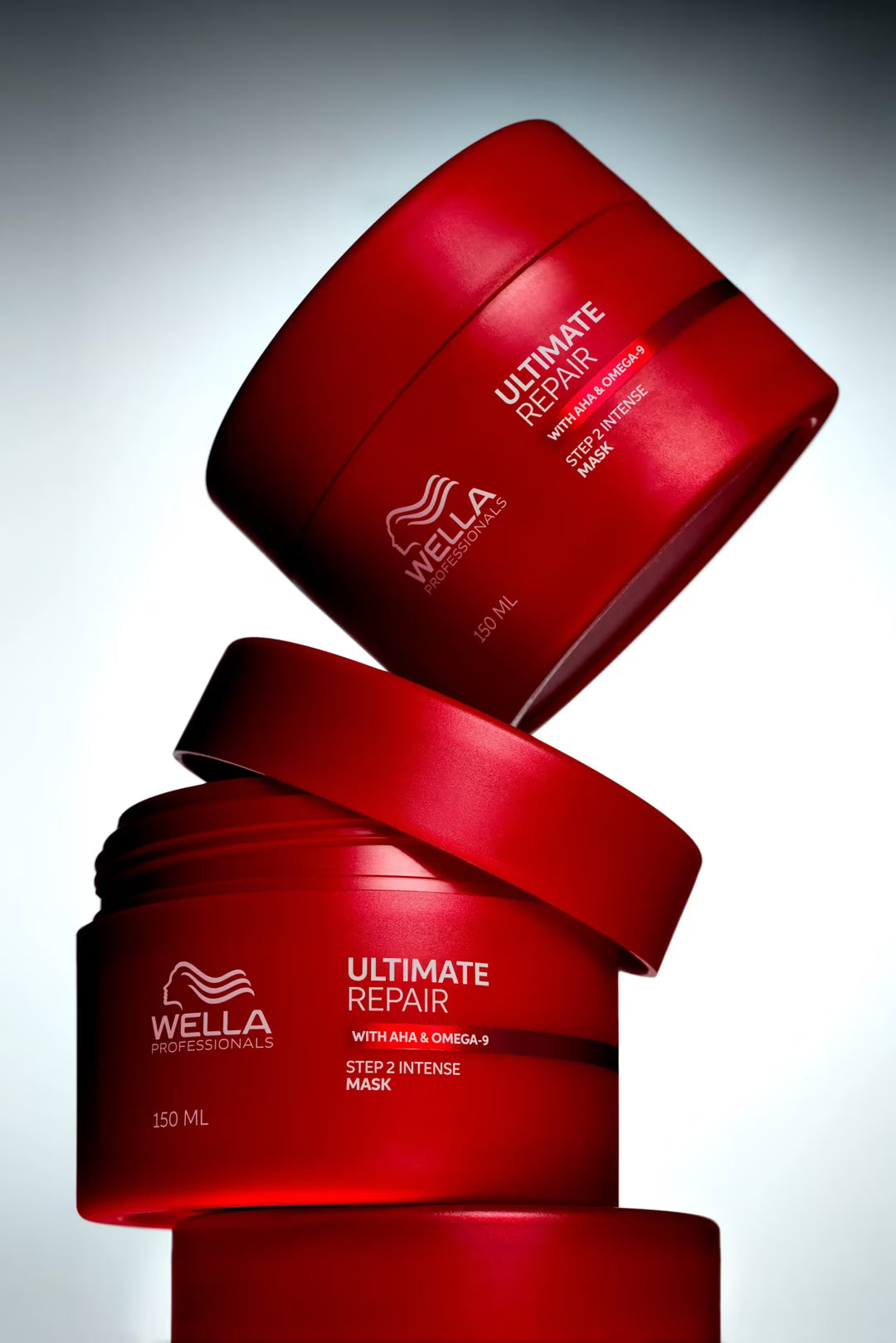 Two red Wella hair mask containers stacked on a gray background