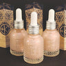 Three Cult and King JELLY glass dropper bottles, containing pink Himalayan salt infusion for hair, are displayed with geometric-patterned boxes on a black surface.