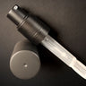 A black and clear spray bottle set against a dark background, with the cap removed and placed next to it, exudes elegance. Its sleek design suggests it contains Cult and King's PUMPABLE HAIR POWDER—a talc-free dry shampoo that adds volume and transforms your beauty routine with its antioxidant-rich formula.