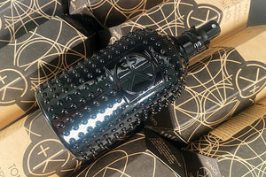 A textured black spray bottle of Cult and King TONIK | Conditioning Hair & Scalp Potion sits atop boxes with geometric patterns and Cult and King branding.