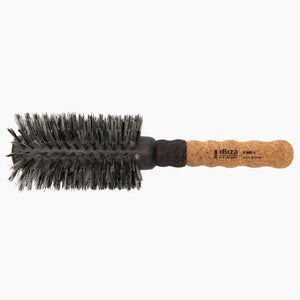 Round hairbrush with black bristles and cork handle on a white background