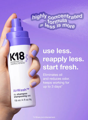 A hand with purple nail polish holds a K18 AirWash Dry Shampoo bottle by K18 Hair Repair against a purple background, featuring text about its concentrated formula, odorBIND™ biotechnology, and benefits.