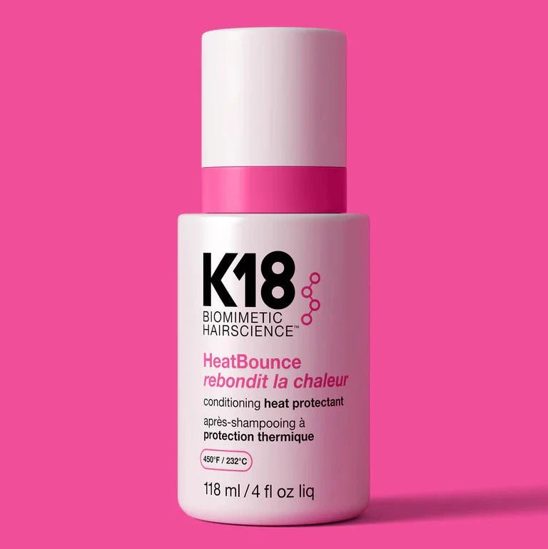 K18 HeatBounce hair product bottle on a pink background