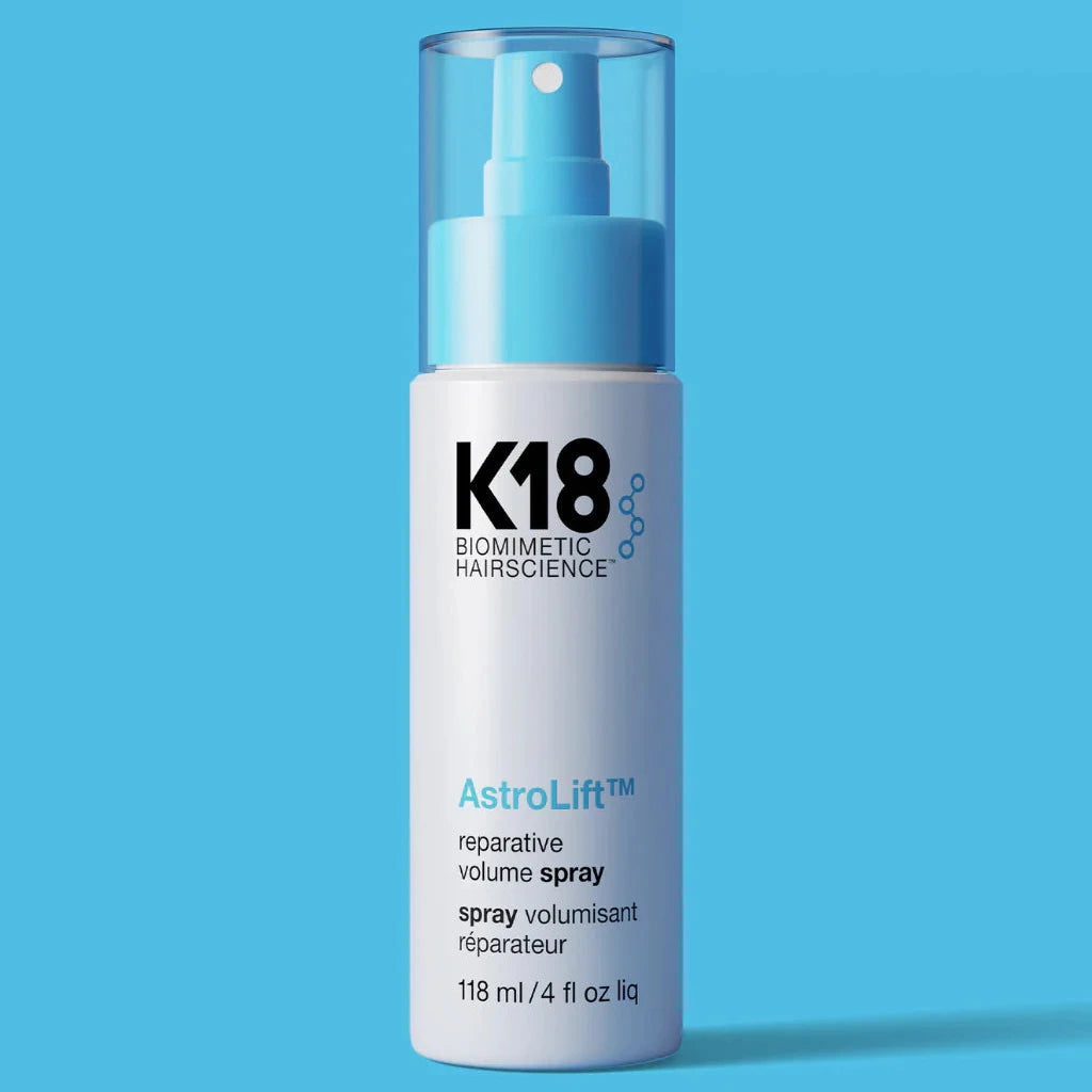 K18 AstroLift hair spray bottle on a blue background