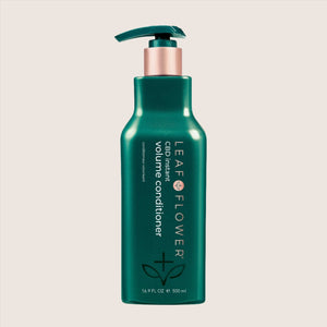 A green bottle of Leaf and Flower Instant Volume Conditioner for fine curly hair, 16.9 fl oz with pump dispenser, is displayed against a light beige background. Multiple sizes are available.