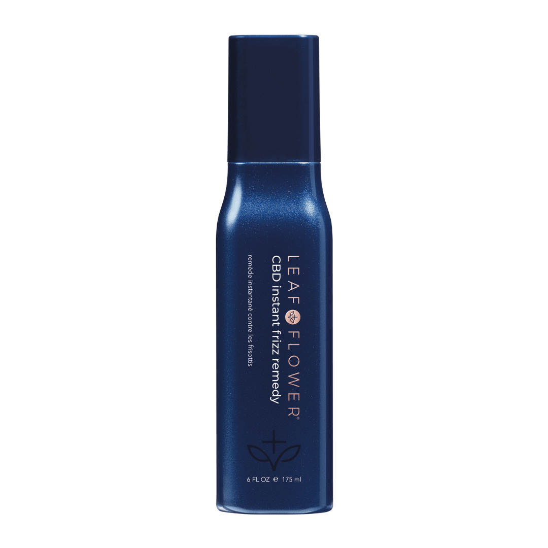 A 6 fl oz (175 ml) blue bottle of Leaf and Flower Instant Frizz Remedy anti-frizz spray with dark blue cap; brand and product name are printed vertically in white for smooth, frizz-free hair.