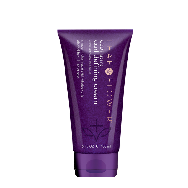 A purple 6 fl oz (180 ml) tube labeled "Leaf and Flower Instant Curl Defining Cream" features white and gold text, a leaf design, and promises frizz-free curls with its plant-based bio-adhesive formula.