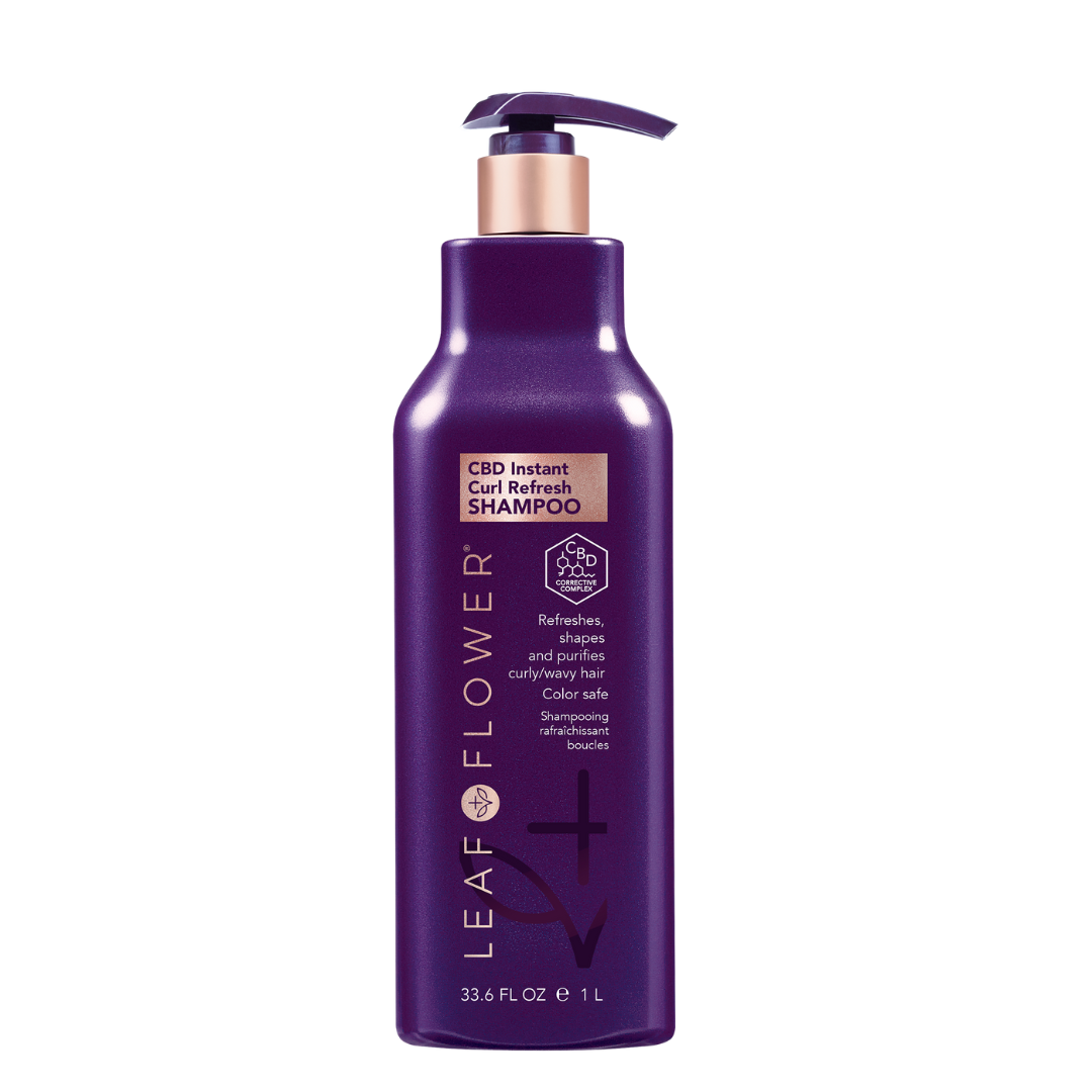 A bottle of Leaf and Flower Instant Curl Refresh Shampoo, with a purple flower, designed to enhance curls by removing build-up and excess natural oils.