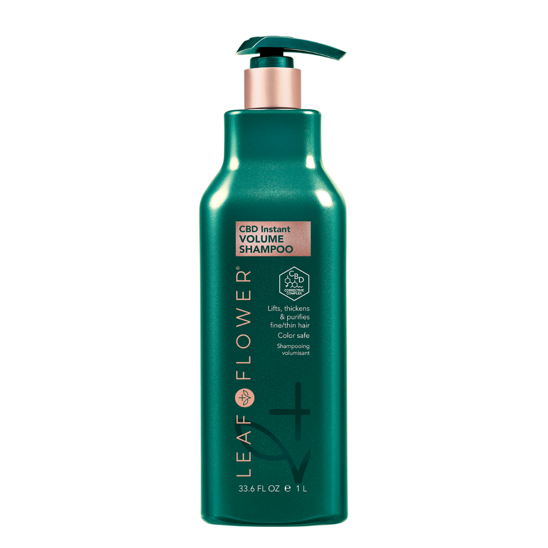 A bottle of LEAF and FLOWER Instant Volume Shampoo for voluminous hair on a black background.