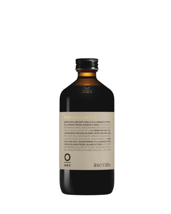 A 240 ml brown Oway bottle with black cap, labeled “Bluemoon Hair Bath | Illuminating Anti-Yellow Shampoo for Cool Blonde, White & Grey Hair,” features a multilingual front label.