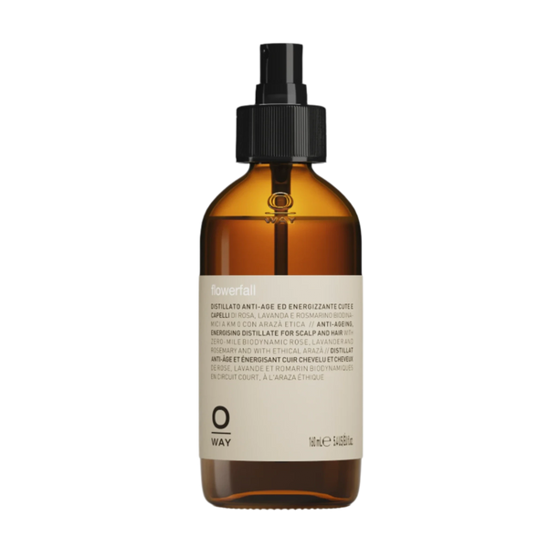 A brown glass spray bottle with a black nozzle and beige label displays "Oway Flowerfall | Aromatherapeutic Scalp and Mind Balancing Mist" by Oway, designed for holistic scalp care.
