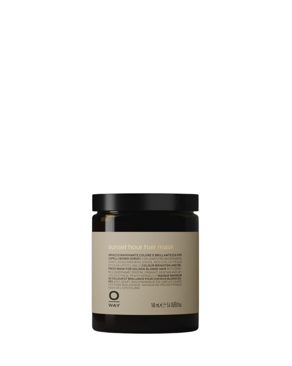 The Oway Sunset Hour Hair Mask is a 480 ml radiance-boosting treatment for golden blonde hair, featuring biodynamic broom to enhance color. Comes in a dark jar with a beige label displaying the Oway logo and product name.