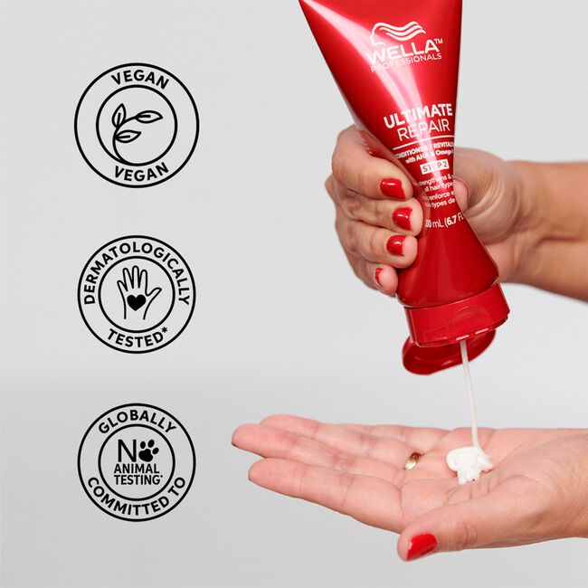 Red Wella bottle being squeezed with cream on a gray background featuring ethical certification logos.